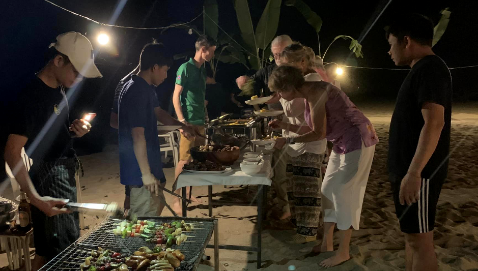 Travelers enjoying a beach barbecue party in Thailand and Laos