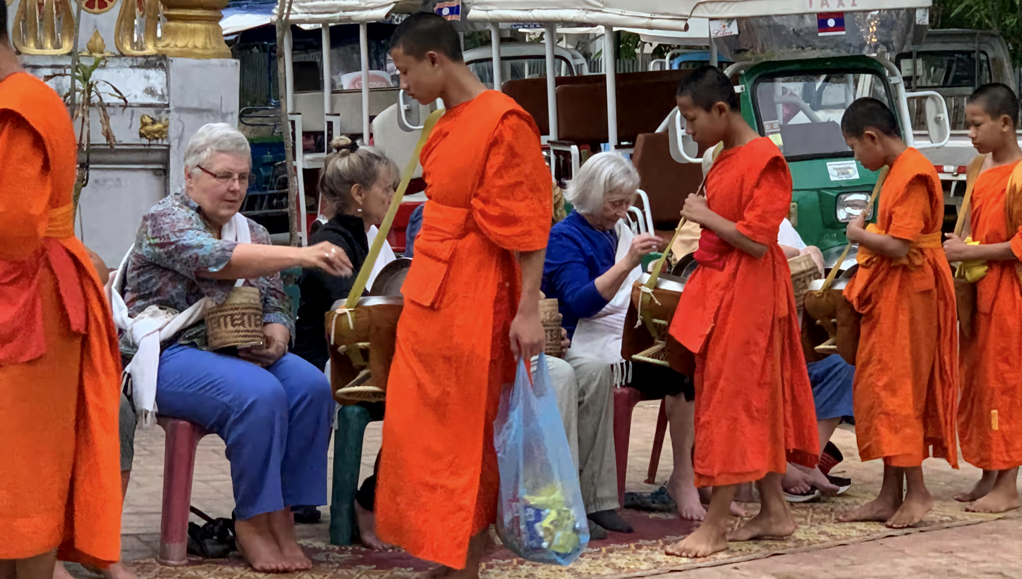 Travelers participating in Alms-giving ceremony in Laos