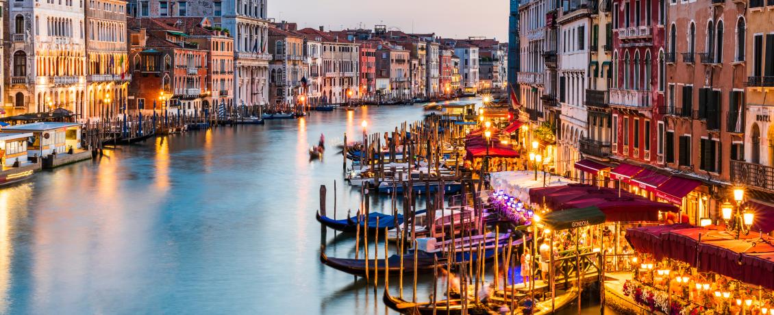 A scenic view of Venice's Grand Canal illuminated by the city lights.