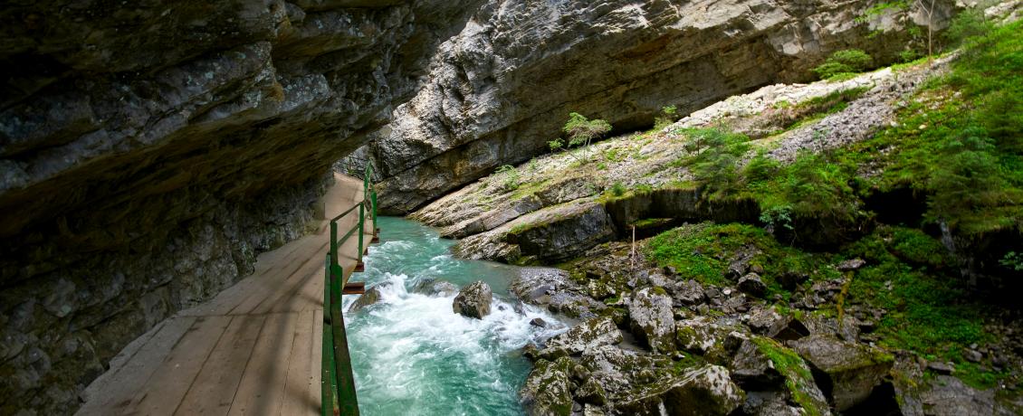 Wooden path along the rocky gorge of Breitachklamm with a flowing river.