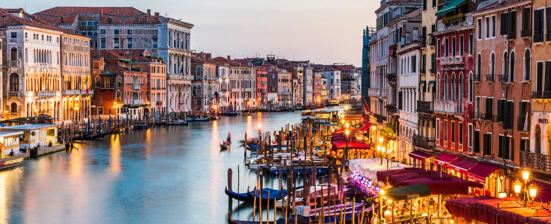 A scenic view of Venice's Grand Canal illuminated by the city lights.